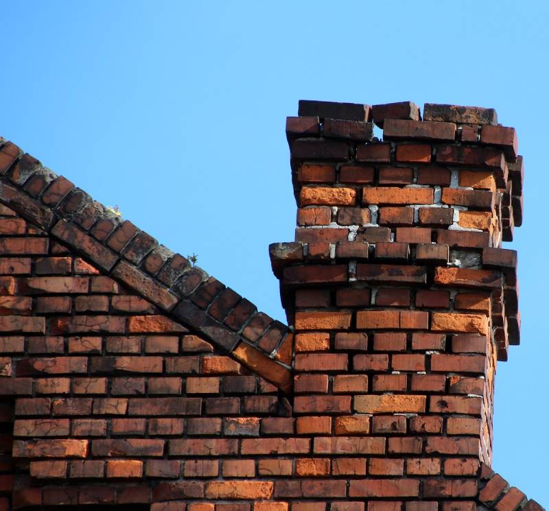 Damaged chimney on an Novi home showing cracks and missing mortar